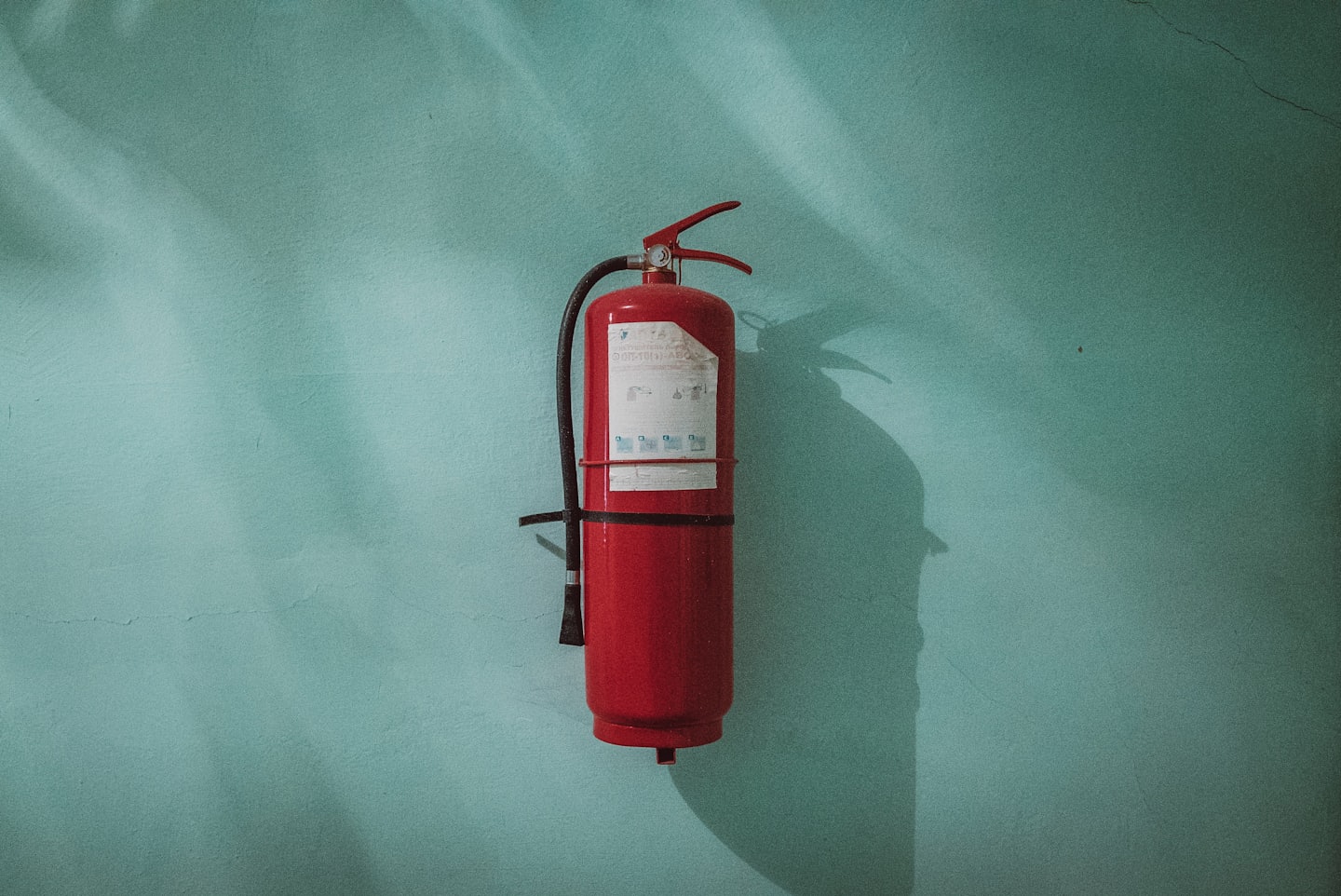 Feuerlöscher der an der Wand hängt.